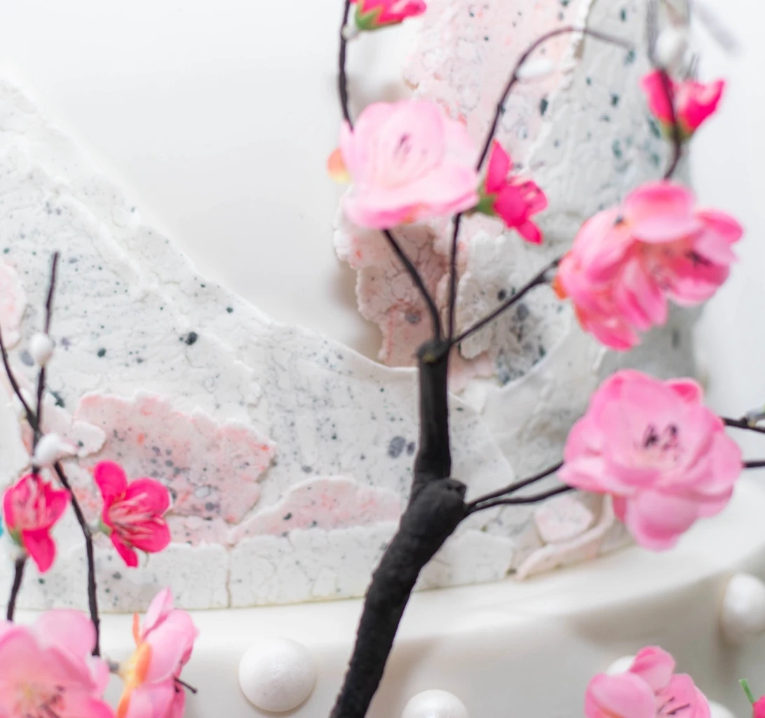 Close-up of handcrafted sugar flowers and textured wedding cake decoration